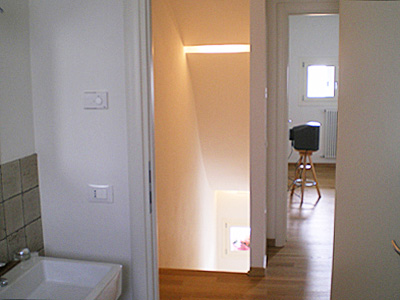 Stairs with curved false ceiling and strip lighting arrangement