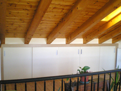 Built-in wardrobe units under sloped attic ceiling